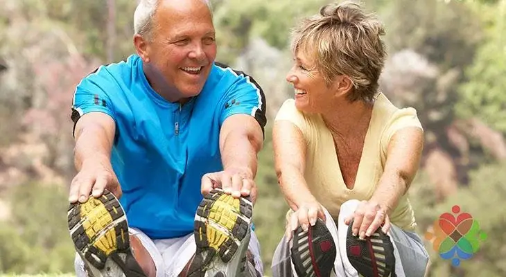 Older couple stretching outdoors to manage holiday stress and stay heart-healthy