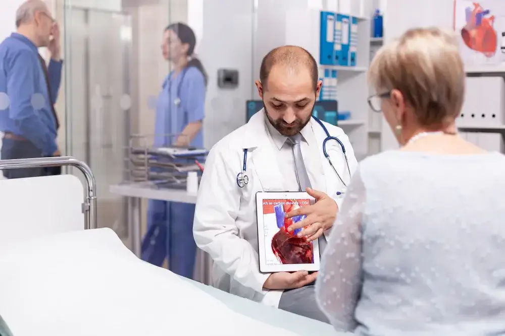AFib doctor showing heart rhythm diagrams to a female patient at Woodlands Heart & Vascular Institute